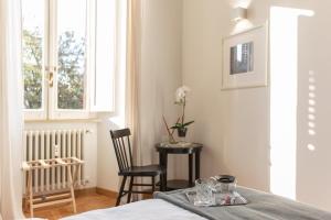 1 dormitorio con mesa, sillas y ventana en Lombardia40 Luxury Suites, en Roma