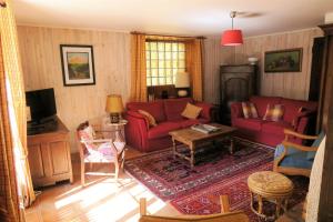 a living room with red couches and a tv at LA FRACELINE in Saint-Pierre-dʼEntremont