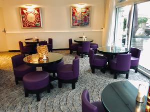 a restaurant with purple chairs and tables in a room at Hôtel Catalpa in Annecy