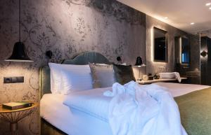 a bedroom with a white bed and a wall at SISSI SUITES | luxury apartments | Mayrhofen in Mayrhofen