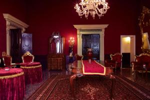 Habitación con paredes y sillas rojas y lámpara de araña. en Palazzo Paruta & Wellness Suites en Venecia