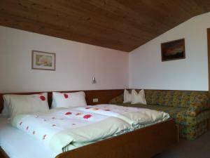 sypialnia z dużym łóżkiem i kanapą w obiekcie Ferienwohnung Angererhof w Reith im Alpbachtal