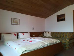 ein Schlafzimmer mit einem großen Bett und einem Sofa in der Unterkunft Ferienwohnung Angererhof in Reith im Alpbachtal