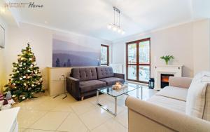 a living room with a christmas tree and a couch at Wonder Home - Apartamenty z balkonami przy szlakach turystycznych - blisko plac zabaw i boisko do gry in Karpacz +25 photos