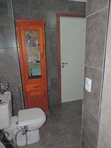 baño con aseo y puerta de madera en Bed and Breakfast Como en Casa en Villa La Angostura