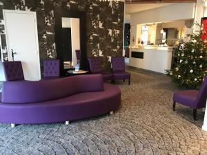 a living room with a couch and a christmas tree at Hôtel Catalpa in Annecy