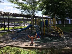 a child playing on a playground in a park at OHANA Sky Villa Residences in Kuching