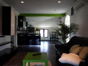 a living room with a black couch and a green table at Apartma Marisol in Izola