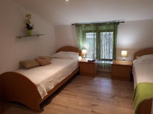 a bedroom with two beds and a window at Apartma Marisol in Izola