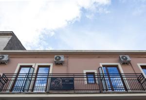 un bâtiment rose avec un balcon et des haut-parleurs. dans l'établissement Pomodoro Bed, à Castrovillari