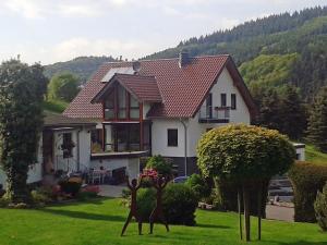 a house with a yard with sculptures in front of it at Nürburgring Apartment in Adenau