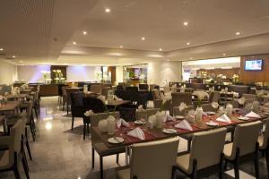 a dining room with tables and chairs and a restaurant at Beach Class International - Flat in Recife
