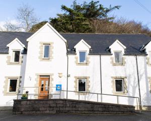 
a white building with a blue roof and white walls at Oban Youth Hostel in Oban
