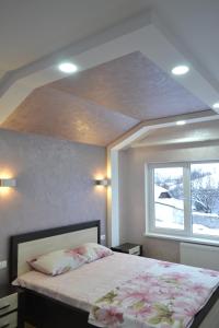 um quarto com uma cama grande e uma janela em Royal House em Kamianets-Podilskyi