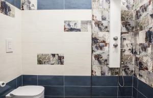 a bathroom with a toilet and blue and white tiles at Pomodoro Bed in Castrovillari