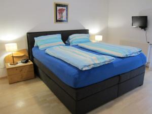 1 dormitorio con 1 cama con sábanas azules y almohadas azules en Landhaus Bürse, en Flattach