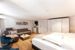 a bedroom with a bed and a couch at Maximilian Apartments Lindau in Lindau