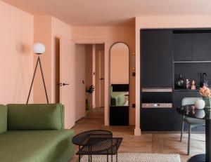 Whitworth Locke في مانشستر: غرفة معيشة مع أريكة خضراء وغرفة نوم