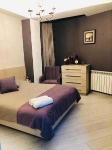 a bedroom with a bed and a dresser and a chair at Chika in Kutaisi