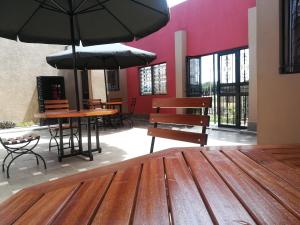 a room with benches and tables with umbrellas at Sunview Lodge & Restaurant in Libwezi