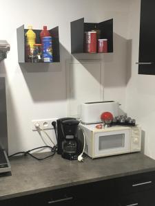 eine Küche mit einer Mikrowelle und einem Stuhl auf der Theke in der Unterkunft appartement terrasseLouhans centre in Louhans