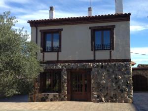 dom z kamiennym budynkiem z oknami w obiekcie Casa Rural El Olivar de Valdefuentes w mieście Valdefuentes