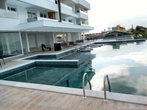 an infinity pool at a hotel with a building at Apartamento Espelho das Águas in Florianópolis