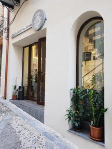 a clock on the side of a building with plants at Ossuna Bay Hotel Boutique in Cefalù