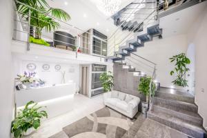 a living room with stairs and plants at Ossuna Bay Hotel Boutique in Cefalù