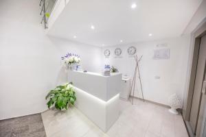a white room with plants on the wall at Ossuna Bay Hotel Boutique in Cefalù