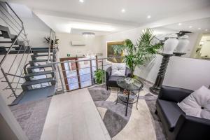 a living room with a staircase and a couch and a table at Ossuna Bay Hotel Boutique in Cefalù
