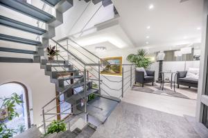 a spiral staircase in a living room with plants at Ossuna Bay Hotel Boutique in Cefalù