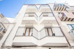 a white building with balconies on it at Ossuna Bay Hotel Boutique in Cefalù