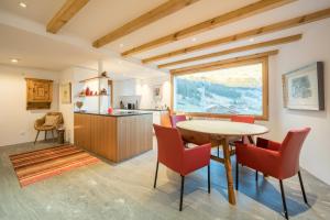 cocina y comedor con mesa y sillas en Casa Alpetta en Flims