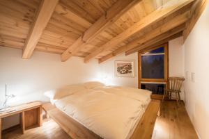 een slaapkamer met een bed, een bureau en een raam bij Casa Alpetta in Flims
