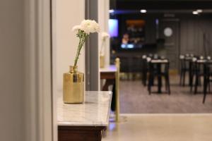 a vase with white flowers sitting on a table at Carsson Hotel Downtown Buenos Aires in Buenos Aires