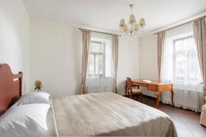 um quarto com uma cama, uma secretária e janelas em BURMISTRO NAMAS em Druskininkai