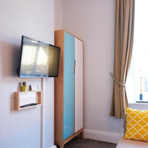 a room with a mirror and a tv on a wall at Corner Beech House in Grange Over Sands