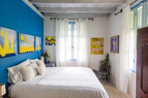 a bedroom with a large white bed with blue walls at Harmony Villa in Pont Cassé