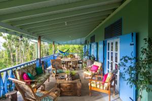 un patio con sillas y una mesa en una casa azul en Harmony Villa, en Pont Cassé