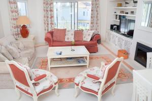 uma sala de estar com duas cadeiras e um sofá em Apartamento Jarro em Quinta do Lago