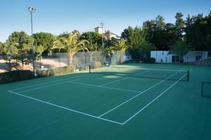 um campo de ténis com uma rede em Apartamento Jarro em Quinta do Lago