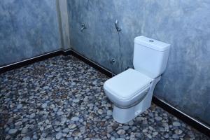 a bathroom with a toilet in a room with rocks at Sea sound cabana & Restaurant in Tangalle