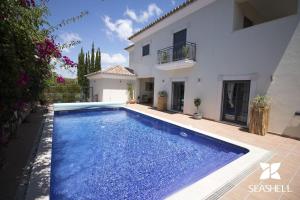una piscina frente a una casa en Villa Esmeralda, en Almancil