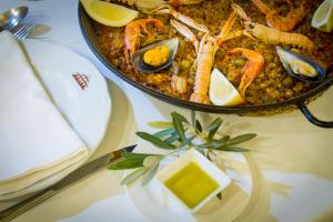 a table with a bowl of food with seafood on it at Hotel Tossal d'Altea in Altea