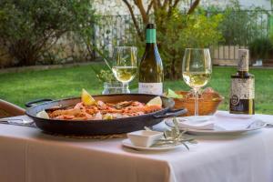 a table with a pan of food and two glasses of wine at Hotel Tossal d'Altea in Altea