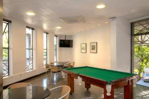 a pool table in a room with tables and chairs at Royal Center Hotel Lourdes in Belo Horizonte