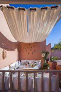 een balkon met een bed en een tafel met eten erop bij Riad El Maktoub in Marrakesh