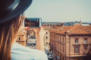 a woman taking a picture of a city with her cell phone at Best Western Plus Hotel De Capuleti in Verona