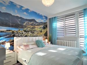 a bedroom with a bed with a view of mountains at VIP Apartamenty Kasprusiowy Zakatek in Zakopane